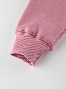 Pink fleece sweatshirt for kids showing ribbed cuff texture and detailed stitching