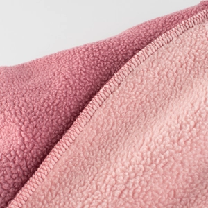 Gros plan sur le tissu polaire corail rose double face avec coutures d'ourlet précises