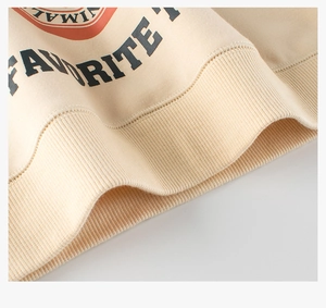 Detail of ribbed hem and vintage letters on a thick cotton sweatshirt in beige