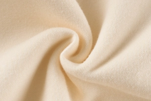 Macro shot of premium light beige knit fabric texture for kids sweatshirts and hoodies