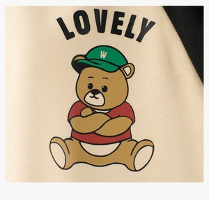 Primer plano del estampado de oso y letras Lovely en la sudadera de forro polar