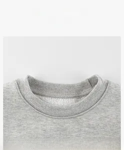 Détail du col côtelé et de la doublure polaire chaude sur un sweat gris pour enfant