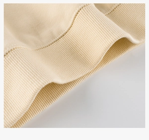 Detalle macro de los puños acanalados y tejido de algodón de una sudadera beige infantil