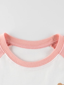 Nahaufnahme des weiß-rosa Raglan-T-Shirts für Mädchen mit geripptem Rundhalsausschnitt