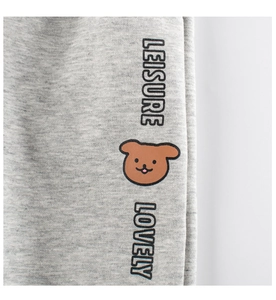 Détail du tissu en maille grise avec motif d'ours mignon et texte LEISURE brodé