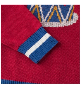 Nahaufnahme von rotem Strickpullover mit gestreiften Rippbündchen und Webmustern
