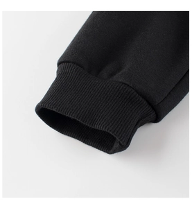 Dettaglio dei polsini a costine sui pantaloni neri in maglia con trama in cotone premium
