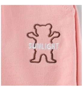 Détail du tissu en maille de coton rose avec broderie ours en peluche et texte Sunlight