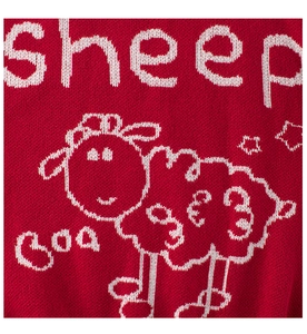 Detail of red knit sweater featuring a white cartoon sheep and knitted stars pattern