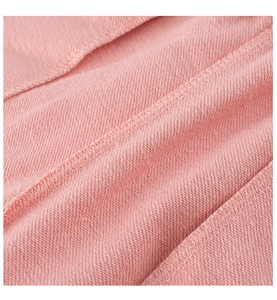 Détail macro du tissu en maille rose doux montrant les coutures de haute qualité