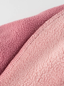 Gros plan sur un tissu polaire rose doux avec couture surjetée pour sweat-shirt enfant