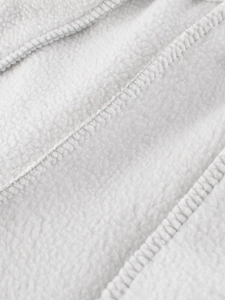 Gros plan du pantalon en polaire blanche pour enfant avec coutures intérieures soignées