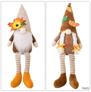 Detail of harvest gnome doll with maple leaf hat and knitted long legs for autumn decor