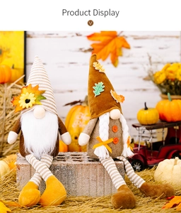 Detail of harvest gnomes with sunflower and maple leaf on rustic autumn setting background