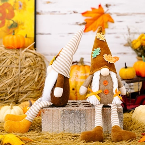 Detail view of harvest gnome set with maple leaves and pumpkins for Thanksgiving decor