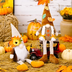 Close-up of harvest gnomes with maple leaf hats in a rustic autumn pumpkin setting