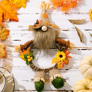Macro detail of Thanksgiving gnome wreath with sunflowers and maple leaves on wood