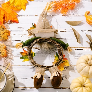Detailed autumn harvest wreath featuring burlap scarecrow and maple leaves on wood