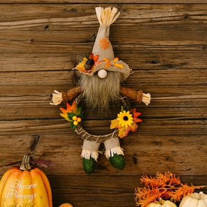 Detail of harvest gnome wreath with burlap hat and sunflowers on rustic wood background