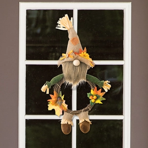 Detail of harvest gnome wreath with burlap hat and maple leaves on woven rattan