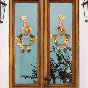 Close-up of autumn gnomes on rattan wreaths with maple leaves and sunflowers on rustic door