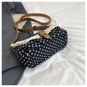 Détail d'un sac à pois rétro avec bordure en dentelle et bandoulière en cuir marron