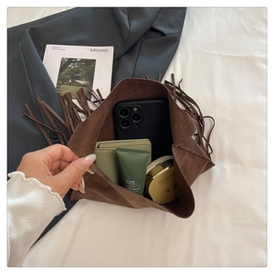 Interior view of brown suede tassel bucket bag showing spacious storage capacity