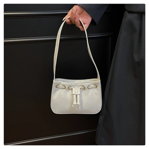 Detail of white leather drawstring handbag with gold metal rings and slim shoulder strap