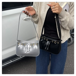 Detail view of stylish underarm bags in black and silver with drawstring accent