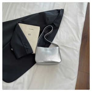 Detail of silver metallic underarm bag showing smooth faux leather and minimalist design