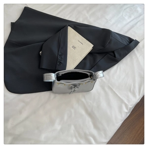 Close-up of the silver metallic mirror finish and interior zipper pouch of the square handbag