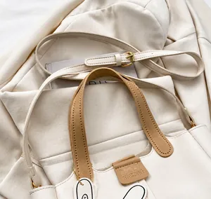 Detail of adjustable shoulder strap and golden metal buckle on beige vintage crossbody bag