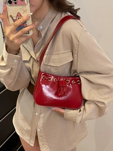 Glossy red patent leather square handbag with drawstring details and gold eyelets