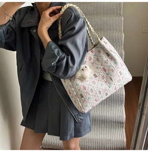 Dettaglio borsa tote color crema con stampe di fiori e orsi e ciondolo a pecora morbida