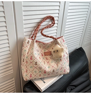 Détail du sac cabas en toile avec motif ours floral et poignées en cuir tressé rose