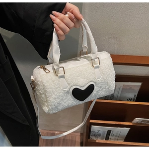 Détail du sac cylindrique en polaire teddy blanc avec patch cœur noir et doré chic