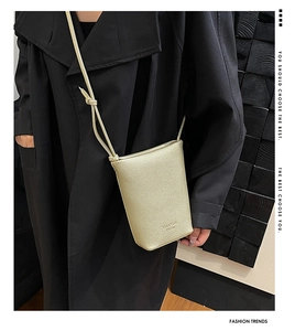 Detail of champagne gold litchi pattern mini bag with knotted shoulder strap design