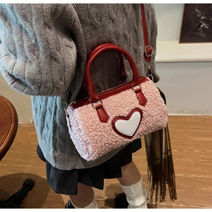 Détail du sac à main en peluche rose avec motif cœur et bandoulière réglable