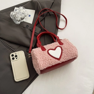Vue détaillée du sac en peluche rose et cuir rouge avec un patch en forme de cœur
