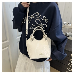 Lifestyle view of a white marbled bucket bag with gold logo and thick dual handles
