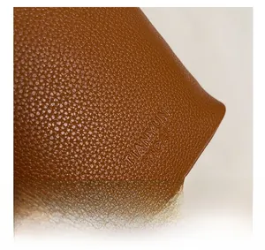 Close-up of brown litchi grain leather texture and TIANYUN brand embossed logo details
