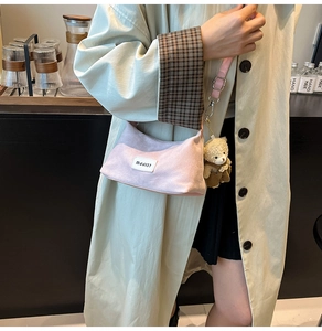Detail of soft pink faux suede shoulder bag with a cute teddy bear charm and MJJ137 label