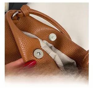 Macro detail of high-quality metallic magnetic clasp and litchi grain leather texture