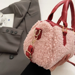 Détail du mini sac boston en peluche rose avec finitions en cuir rouge et métal doré