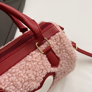 Détails de la texture peluche rose et du patch cœur sur le sac à main cylindrique