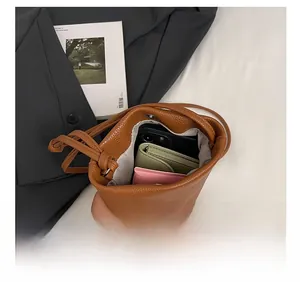 Internal view of brown leather bucket bag showing large capacity for phone and wallet