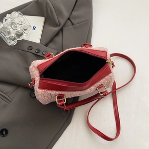 Vue détaillée du sac en peluche rose avec lanières en cuir rouge et boucles en métal doré