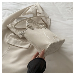 Close-up of cream marble pattern handbag with glossy finish and brand lettering