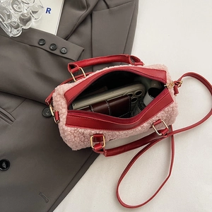 Sac à main en peluche rose avec finitions en cuir rouge montrant l'espace intérieur