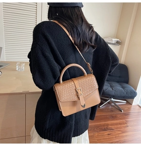Détail du sac bandoulière camel vintage avec rabat tissé et boucle en métal dorée